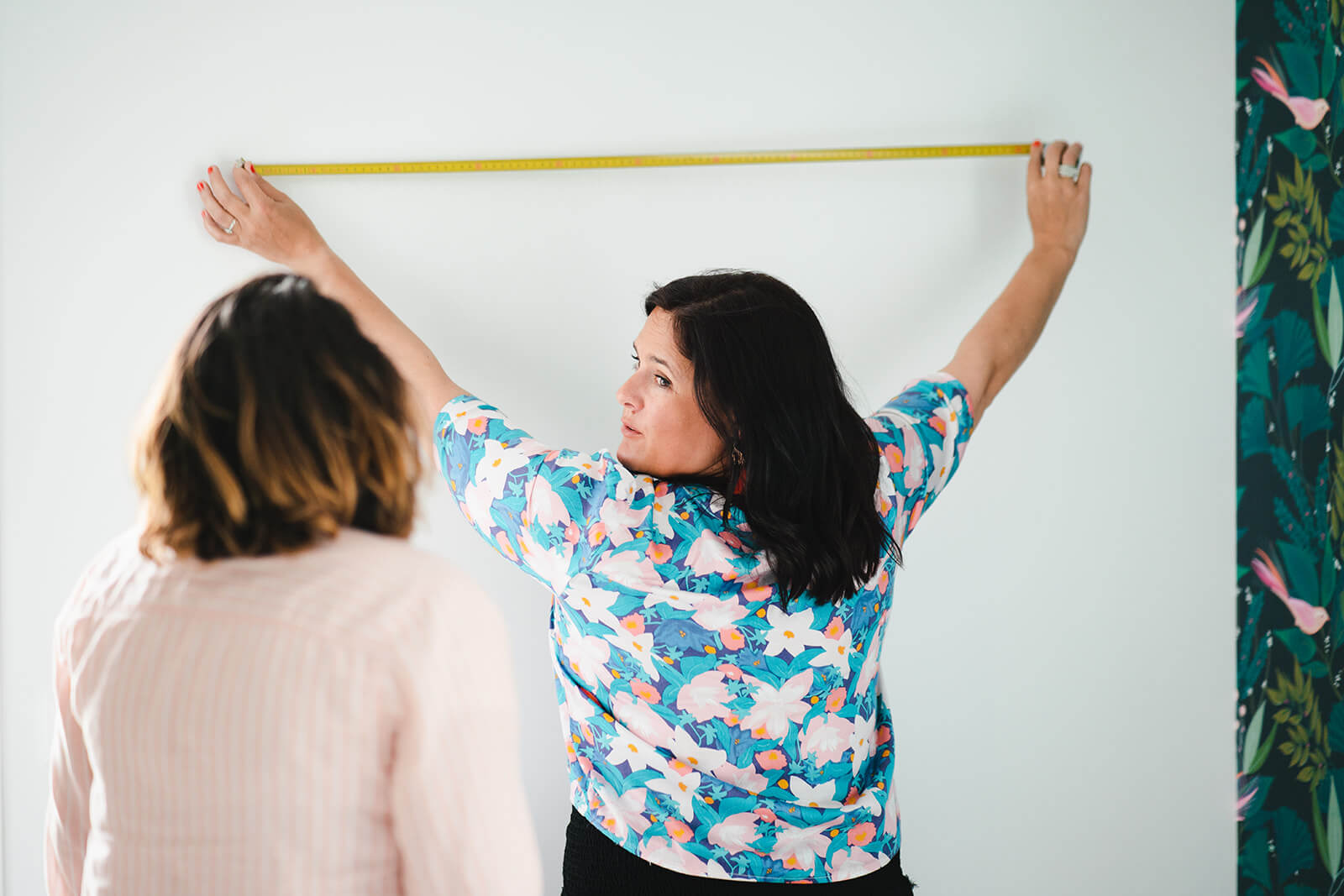 Lucie mesure un mur devant une cliente